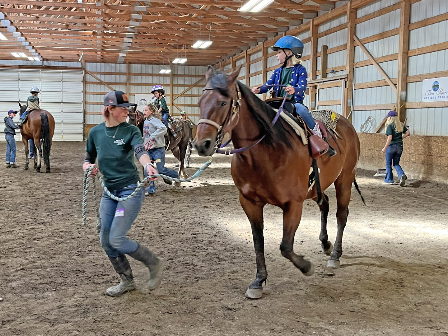 Kid Learning To Ride In Indoor Arena Cedar Ridge Equine